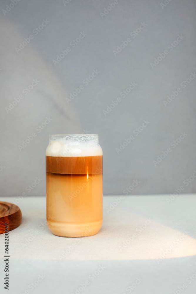 Coffee with milk, cappuccino, latte with foam in a transparent glass cup on a light concrete background. Front view Coffee with milk, cappuccino, latte with foam in a transparent glass cup on a light concrete background. Front view