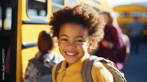 Portrait of elementary grade child sitting in school bus. Yellow bus taking children on sunny autumn day. Back to school concept.