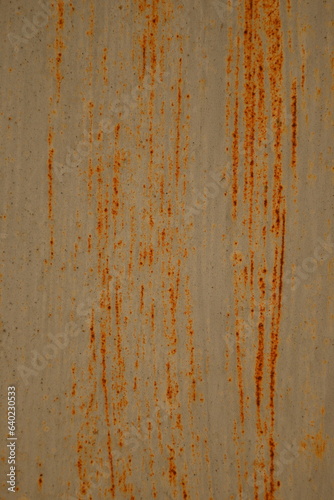 Orange rusty surface of old iron. Corroded metal background. Rusted white painted metal wall. Rusty metal background with streaks of rust. Rust stains. The metal surface rusted spots.