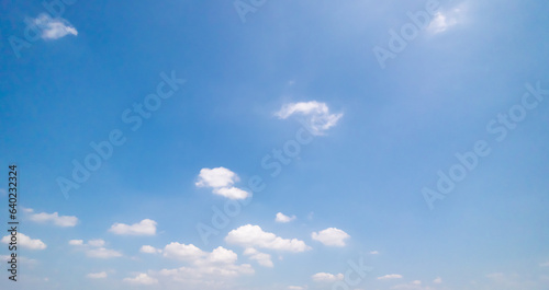 Panoramic view of clear blue sky and clouds, Blue sky background with tiny clouds. White fluffy clouds in the blue sky. Captivating stock photo featuring the mesmerizing beauty of the sky and clouds.