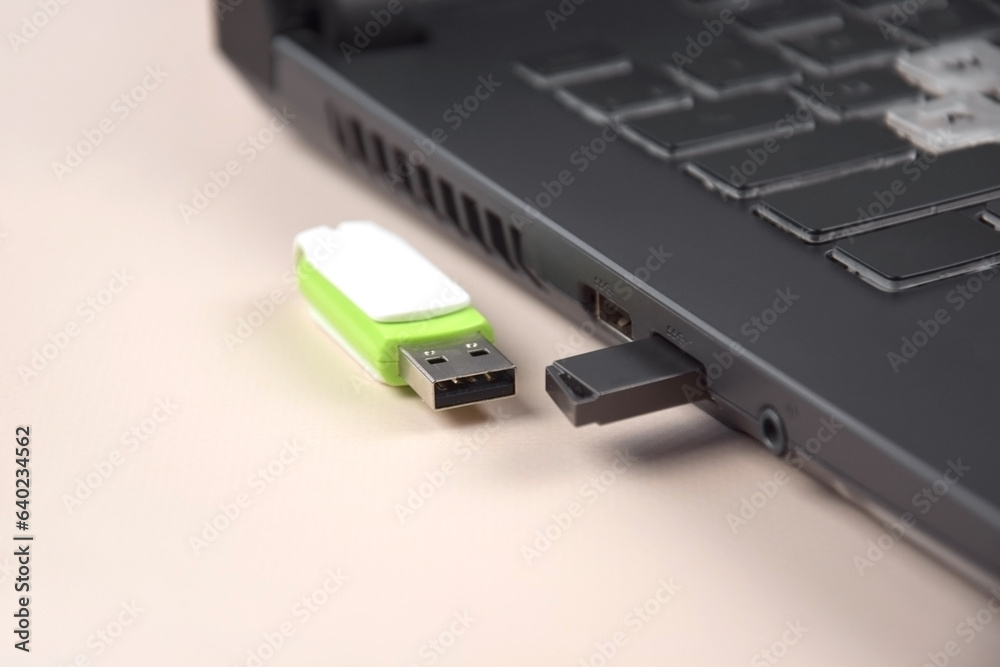 USB memory stick or flash drive on the keyboard of an open laptop. USB memory stick or flash drive on the keyboard of an open laptop.