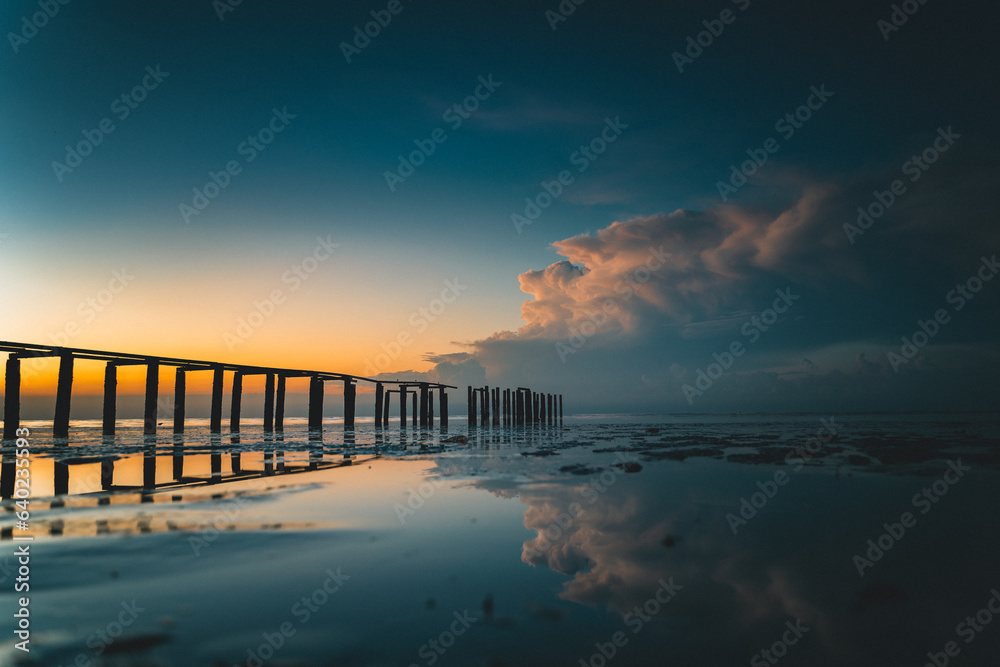 Sky with cloud during sunrise at the beach with broken wooden jetty along the sea at Gertak Sanggul, in Penang, Malaysia.