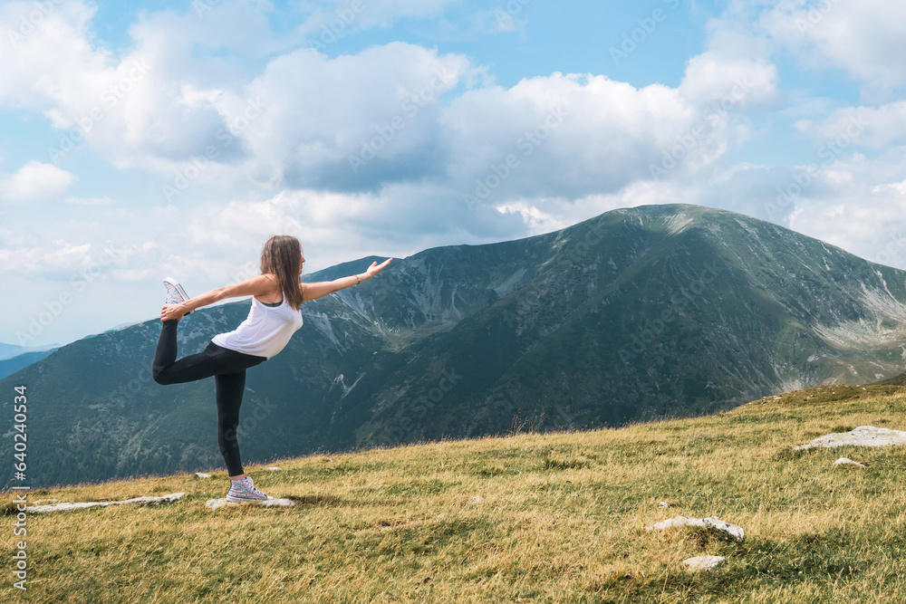 A beautiful young woman relaxes practicing meditation and yoga exercises in nature in a mountain landscape. Relaxation and meditation on vacation. A beautiful young woman relaxes practicing meditation and yoga exercises in nature in a mountain landscape. Relaxation and meditation on vacation.