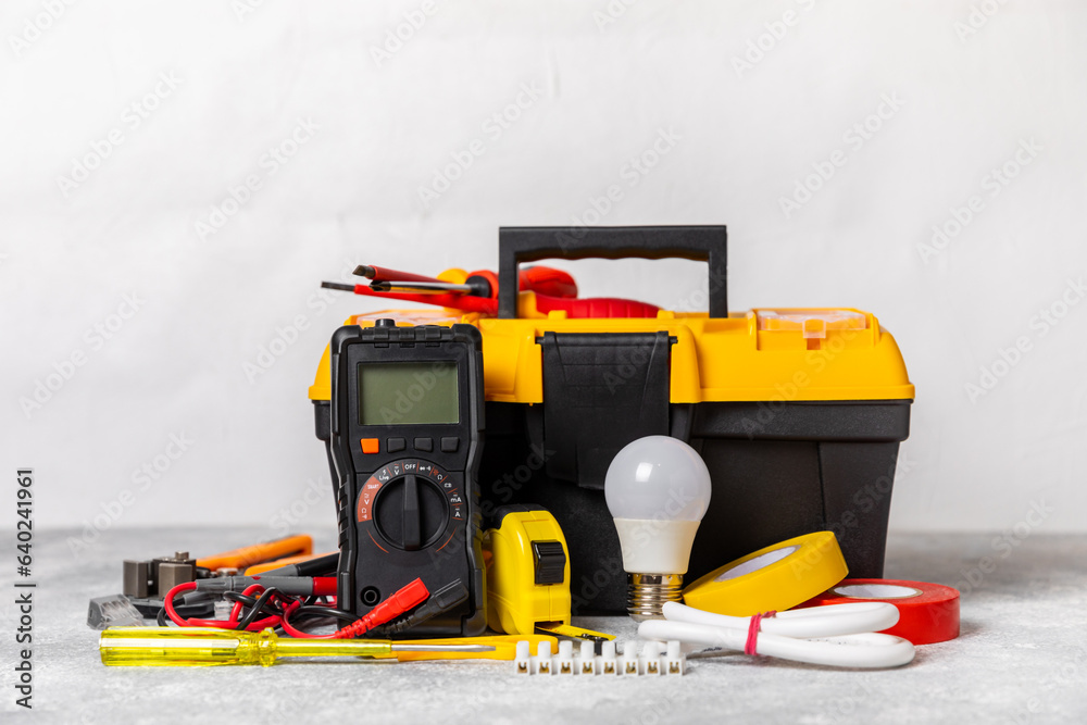 Electrician equipment on marble background with copy space.Top view.Electrician tool set.Multimeter, tester,screwdrivers,cutters,duct tape,lamps,tape measure and wires.Flet lay. Construction concept.