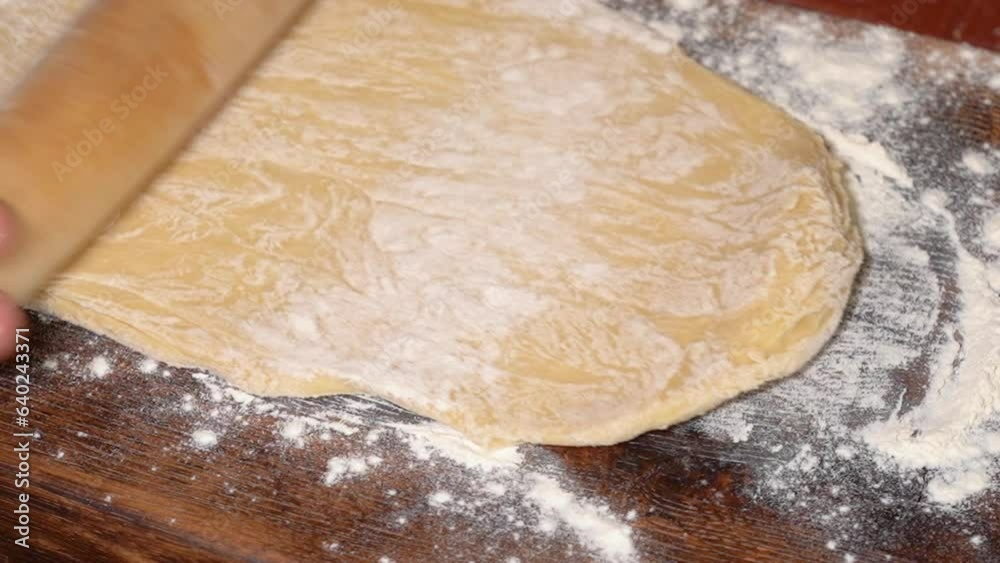 Process of homemade bake with wheat flour. The cook uses a rolling pin