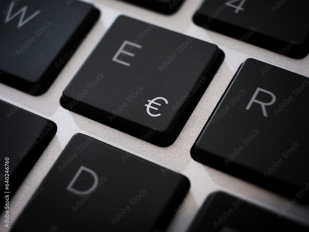 Black € euro sign key macro on a laptop keyboard Black € euro sign key macro on a laptop keyboard