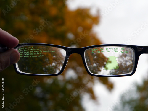 Cropped hand holding smart glasses against trees