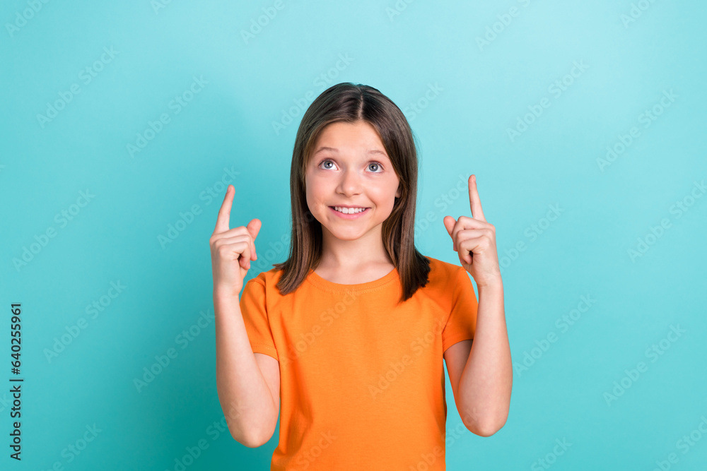 Portrait of small mommy daughter girl directing fingers up up empty space wear orange t-shirt isolated cyan color background Portrait of small mommy daughter girl directing fingers up up empty space wear orange t-shirt isolated cyan color background
