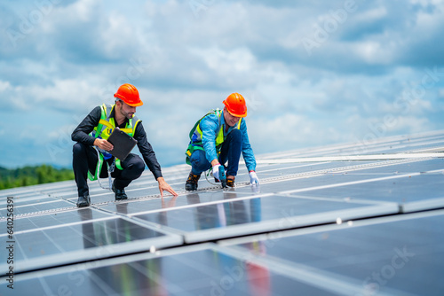 Technician engineer planning to setting solar panel on the roof of the building to work at full efficiency, Using solar cells for energy saving to save and protect environment. Renewable energy