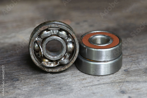  old rusty and damaged ball bearing on wood table . 