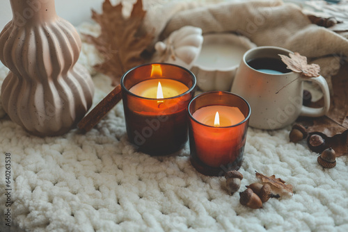 Two burning candles in the autumn interior