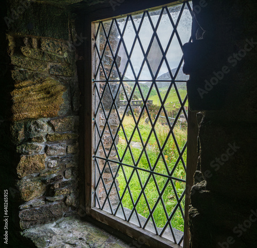 Leaded  glass window overlooking churchyard in Scotland 