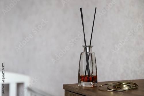 Reed diffusor in domestic interior. Cozy home atmosphere. Concept of relaxation with aromatherapy. Photo with copy space