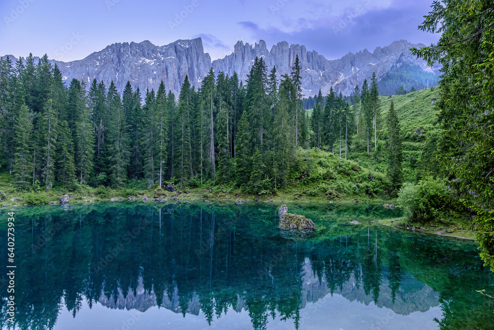 Tranquil Lago di Carezza during cloudy summer twilight in the Italian Dolomites