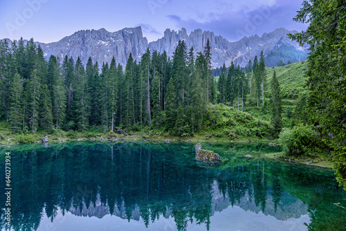 Tranquil Lago di Carezza during cloudy summer twilight in the Italian Dolomites