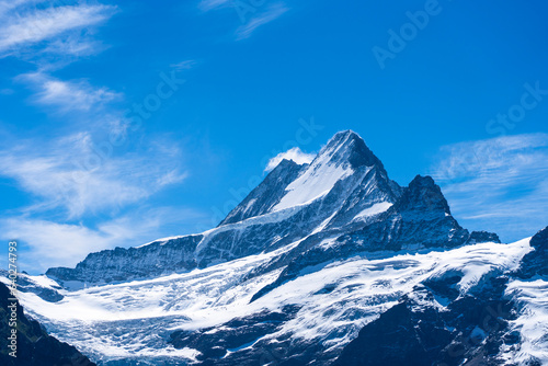 Snow covered Mountain in Switzerland among the backdrop of a blue sky 