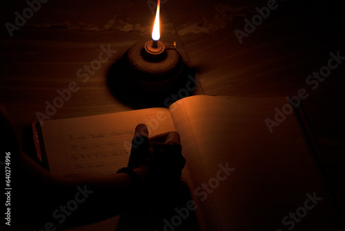 Student in rural village studying in oil lamp