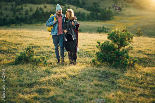 Couple of hikers walking along mountain grassy trail during a vacation © Zamrznuti tonovi