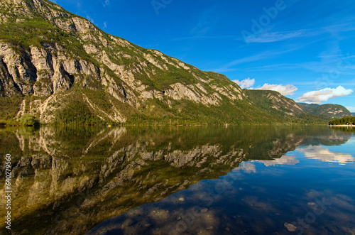 Astonishing panoramic nature landscape of scenic mountain range which reflected in turquoise water of Bohinj Lake, Triglav National Park, Slovenia. Concept of landscape and nature