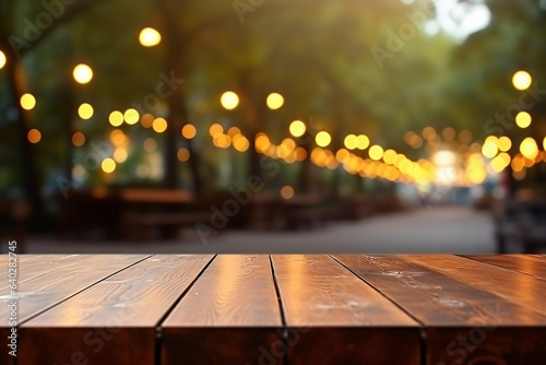 Empty wooden table with leaves and bokeh lights blurred outdoor cafe background. High quality photo