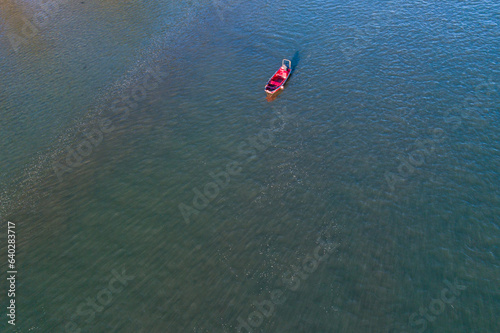 drone aerial view of a red ship in a calm sea