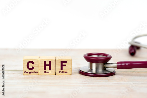 Word Congestive Heart Failure (CHF) on wooden blocks and stethoscope on the wooden table with white background for copy space. Medical concept. photo
