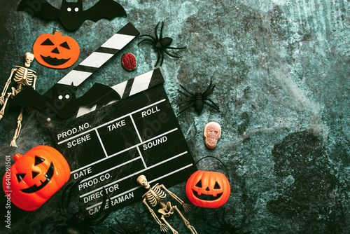 Halloween movies concept. Movie clapperboard with funny halloween pumpkin,skeletons and spiders. Halloween concept background
