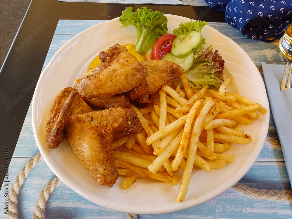 Deep fried chicken wings with fried potatos