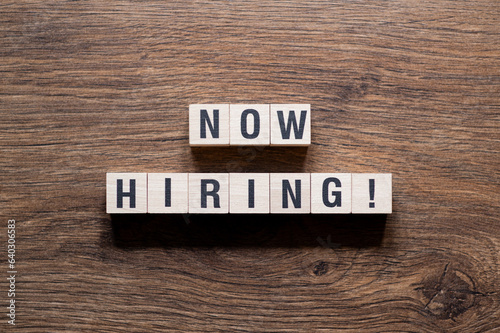 Now hiring - word concept on building blocks, text