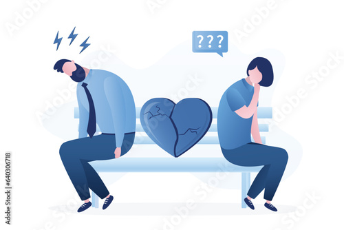 Unhappy couple sitting on a bench with a broken heart. Love in past, cracked heart, family conflict. Divorce and breakup. Sad people sit on the bench.