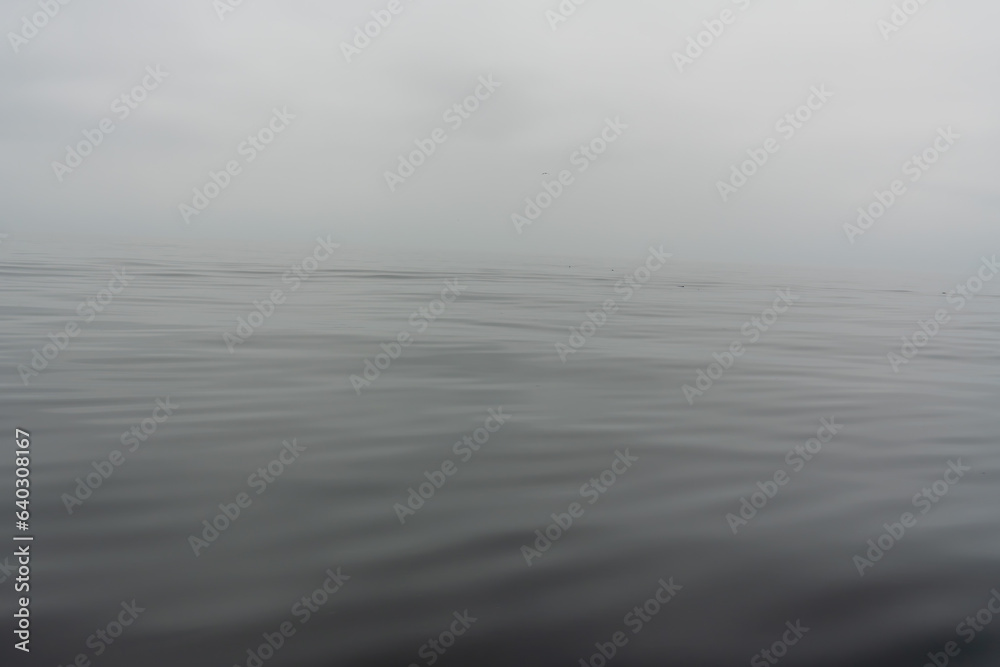 Smooth Ocean or Sea on a misty foggy morning abstract background with copy space.