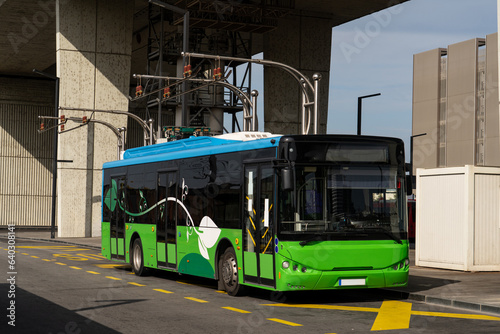 Electric bus at a stop is charged by pantograph. Clean mobility