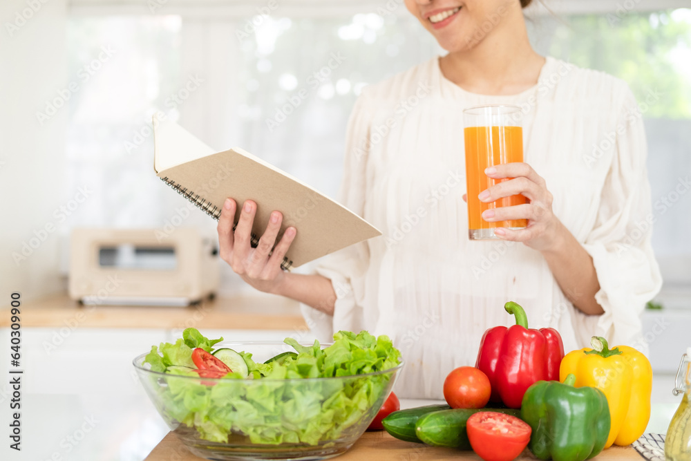 Woman reading recipe for simple summer salad in cookbook. Simple healthy food concept