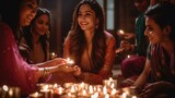 Young Indian women sit at table in dark room lighting diyas. Females smile cheerfully talking in light of numerous candles. Hindu people celebrate holiday of Diwali on blurred background
