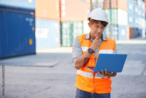 factory worker or engineer working on laptop computer in containers warehouse storage