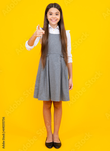Full length of cheerful teenager child girl wearing comfy trendy fashion clothes, isolated over yellow background.