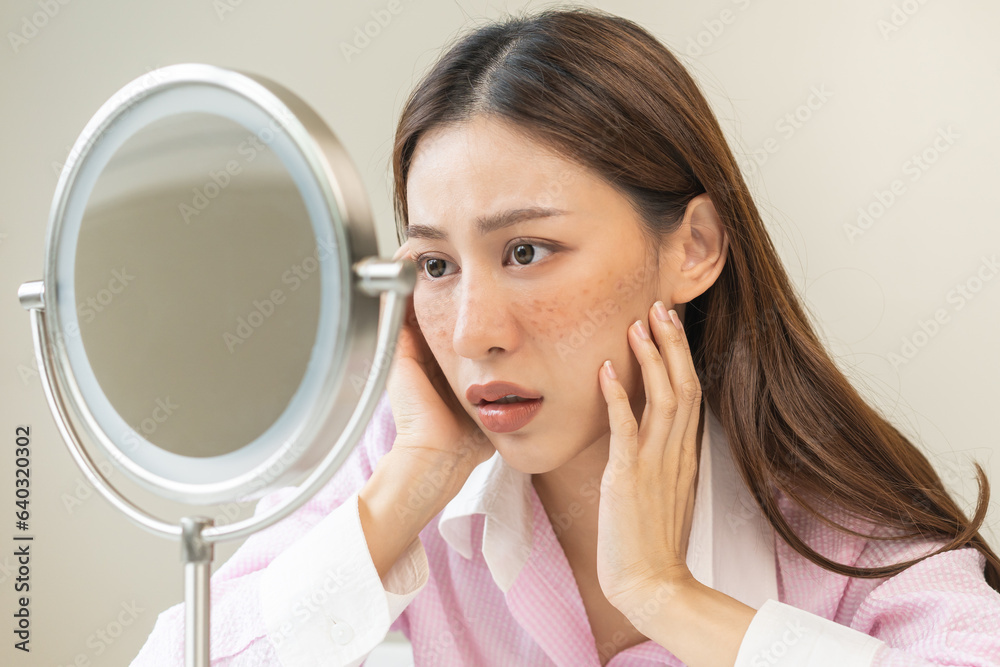 Dermatology, expression face worry asian young woman looking mirror hand touch facial at dark spot of melasma, freckles from pigment melanin, allergy sun. Beauty care, skin problem treatment, skincare Dermatology, expression face worry asian young woman looking mirror hand touch facial at dark spot of melasma, freckles from pigment melanin, allergy sun. Beauty care, skin problem treatment, skincare