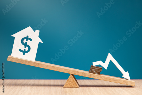 Reducing the interest rate on mortgages in the United States. Reducing the cost of a loan for real estate or rental housing. Model of a house with a dollar symbol on the scales.