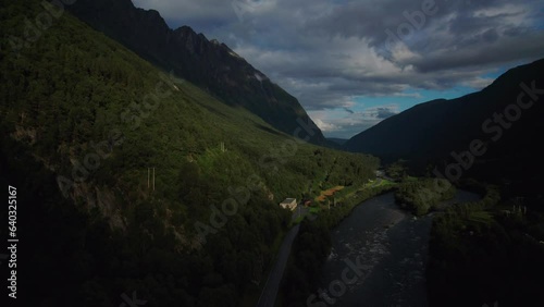 Aerial Establishing shot, valley between mountain ridges. Soaring drone above a road and the river Driva in Norway photo