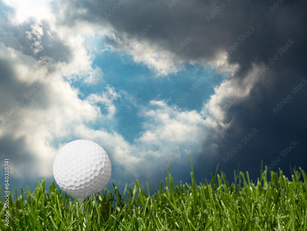 Golf white ball on tee on green grass Golf white ball on tee on green grass