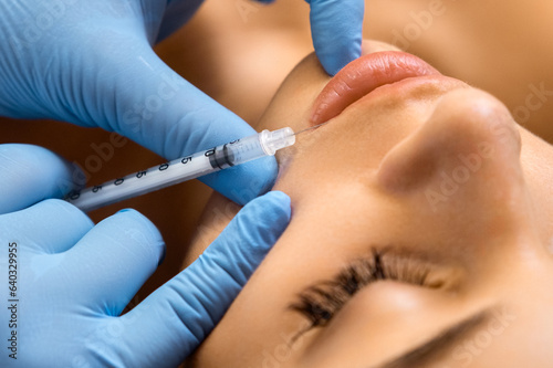 Lip augmentation procedure with hyaluronic acid in a beauty salon.