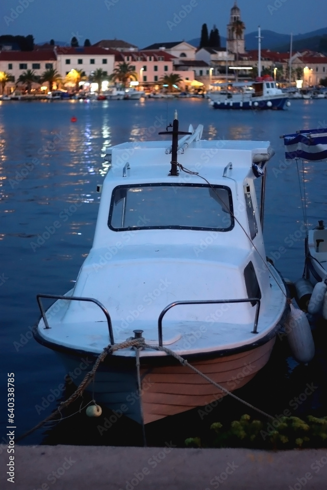 Naklejka premium Small boat moored in Vela Luka, on island Korcula, Croatia. Selective focus, blue evening light.