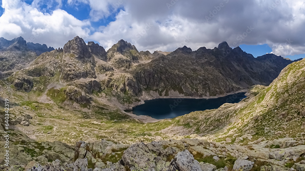 Panoramic view of glacier lake Lac du Basto in the Mercantour National Park in the Valley of Marvels near Tende, Provence-Alpes-Côte d'Azur Alpes-Maritimes, France. High mountain ridges in French Alps