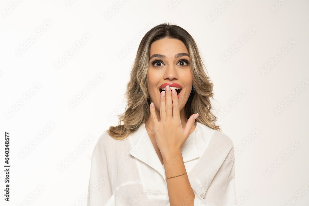 beautiful young surprised happy women with makeup and long wavy hair on a white background. beautiful young surprised happy women with makeup and long wavy hair on a white background.