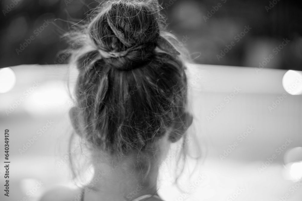Obraz na płótnie Tył głowy dziewczynki z długimi włosami upiętymi w kok. w salonie