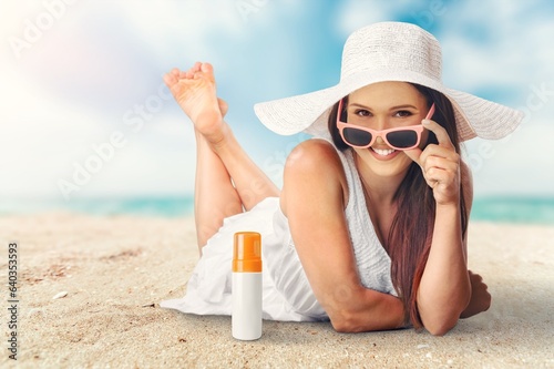 stylish young woman with sunscreen sitting at the beach.