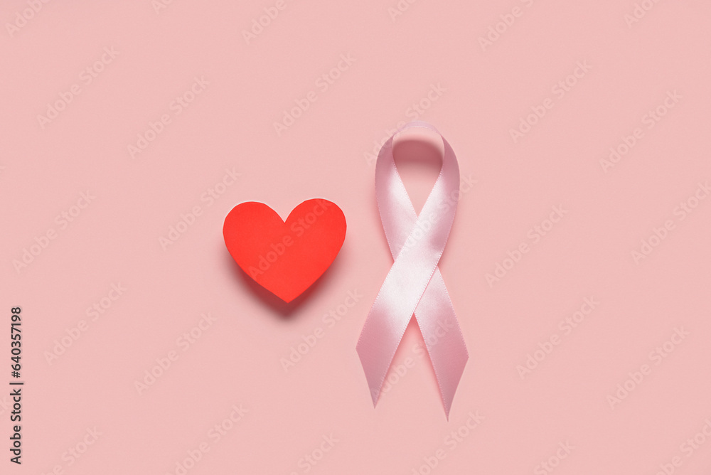 Pink awareness ribbon and red heart on color background. Breast cancer concept Pink awareness ribbon and red heart on color background. Breast cancer concept