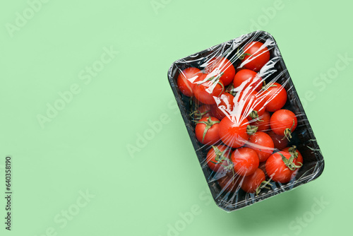 Quadro em tela Plastic container of fresh tomatoes wrapped with stretch wrap on color backgroun