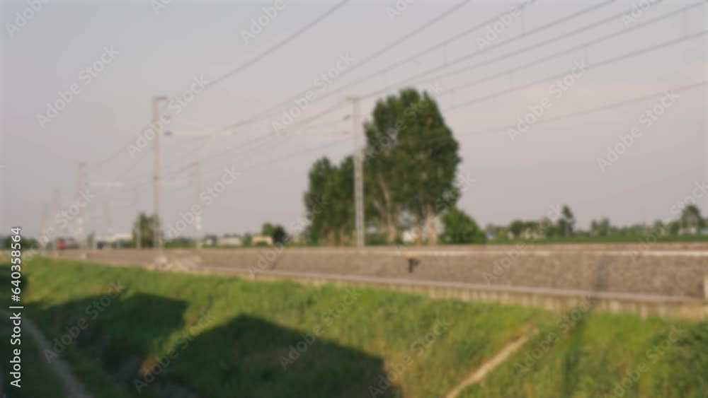 Background, blurry image. The movement of a high-speed electric train by rail in Italy.