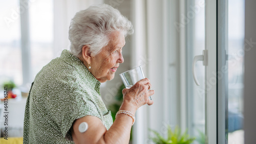 Senior woman drinking water to better manage her diabetes.